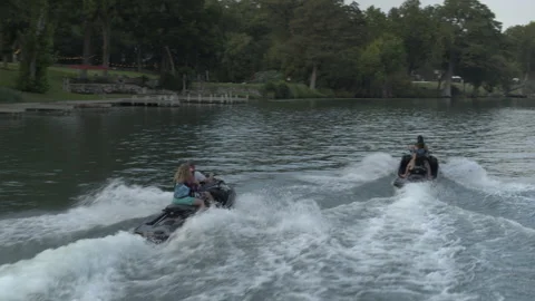 Jet skis churn up waves in the river, friends having fun Stock Footage 323463511