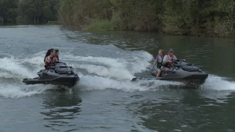 Jet skis race side by side, kids wave to each other Stock Footage 323465838