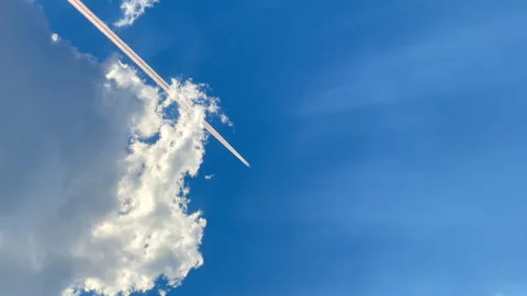 Jet trail in cloudy blue sky Stock Footage 272145274