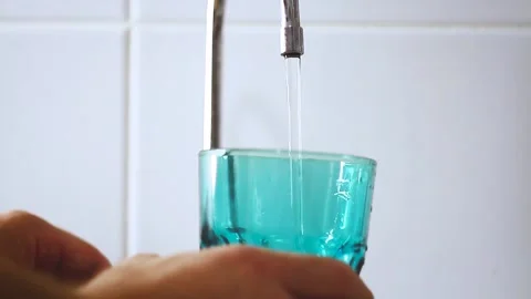 A jet of water flows into a glass. Drinking water from a tap. The man is Stock Footage 207832046