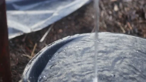 The jet of water flows non-stop and overflows the plastic bucket Vídeos de archivo 171051282
