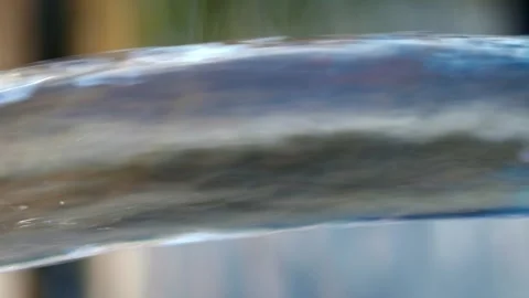 Jet of water flows out of a blue swimming pool onto wooden decking Stock Footage 250006583