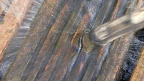 Jet of water flows out of a blue swimming pool onto wooden decking Stock Footage 250006598