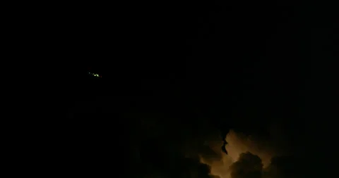 Jetliner avoids a dangerous thunderstorm as lightning forks the night sky. Stock Footage 319359195