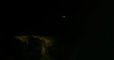 Jetliner avoids a dangerous thunderstorm as lightning forks the night sky. Stock Footage 320336920