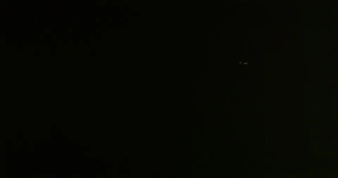 Jetliner flees a dangerous storm in a night sky illuminated by lightning. Stock Footage 320332889