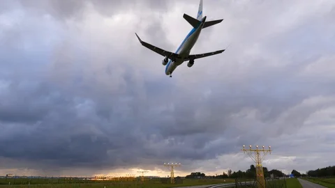 Jetliner landing, wide low angle shot, plane pass by against overcast sky Stock Footage 129199198