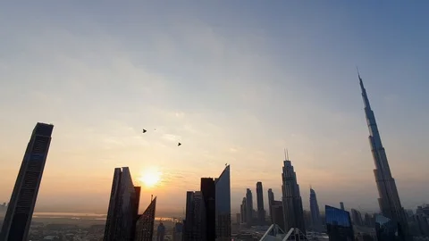 Jetmen with engine packs flying over the Dubai Burj Khalifa skyline Stock Footage 121378036