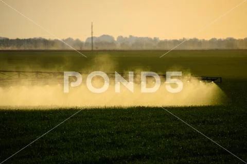Jets of liquid fertilizer from the tractor sprayer. Stock Photos