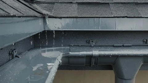 Jets of rain drain into the drainage system on the roof of the house Stock Footage 135150631