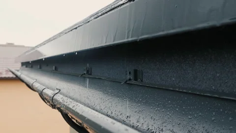 Jets of rain drain into the drainage system on the roof of the house Stock Footage 135150705