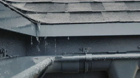 Jets of rain drain into the drainage system on the roof of the house Stock Footage 139935510