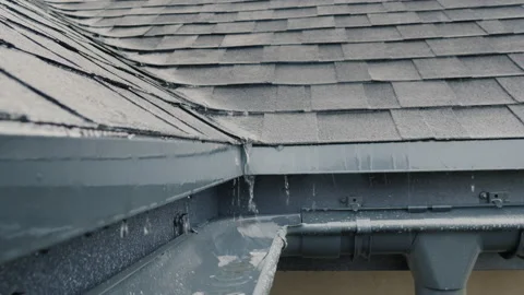 Jets of rain drain into the drainage system on the roof of the house Stock Footage 146359554