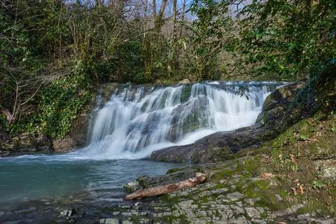 The jets of the waterfall flow into a mountain river Foto stock