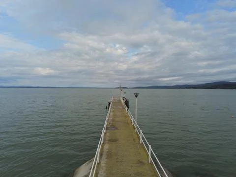 Jetty on the lake with clouds in the sky Stock Photos