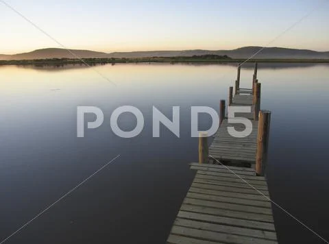 Jetty on tranquil river Stock Photos