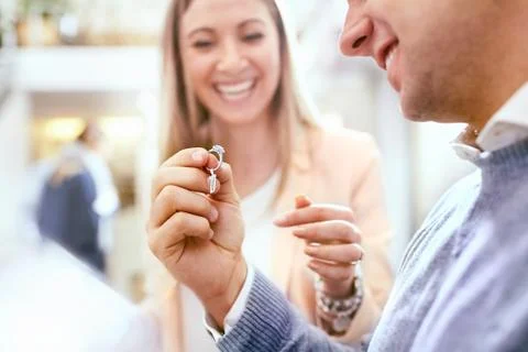 Jeweler helping man shopping for diamond ring in jewelry store Stock Photos