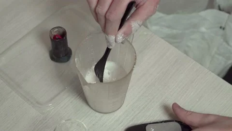 A jeweler prepares a plaster solution for pouring into a mold with a wax model. Stock Footage 147414770