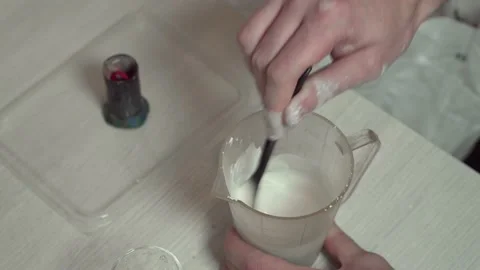 A jeweler prepares a plaster solution for pouring into a mold with a wax model. Stock Footage 147414855