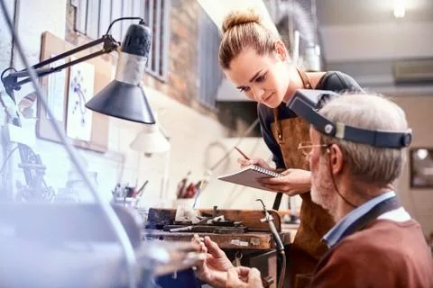 Jeweler teaching apprentice in workshop Stock Photos