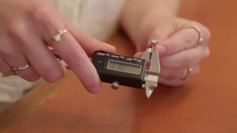 Jeweler using digital calipers to measure diamond ring size in workshop. Stock Footage 337164038