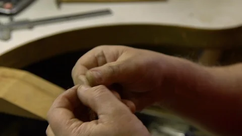 Jeweler in the workshop pulls the chain through the fellier Stock Footage 108343261