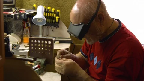 Jeweler in the workshop pulls the chain through the fellier Stock Footage 108343311