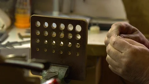 Jeweler in the workshop pulls the chain through the fellier Stock Footage 108343396