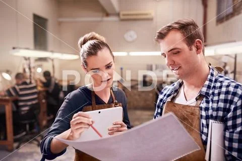 Jewelers with digital tablet and blueprints in workshop Stock Photos