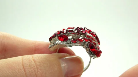 Jewelery ring with red ruby crystals putting on the finger Stock Footage 32222194