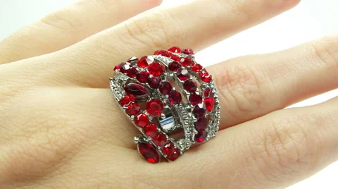 Jewelery ring with red ruby crystals purring on the finger Stock Footage 32662396