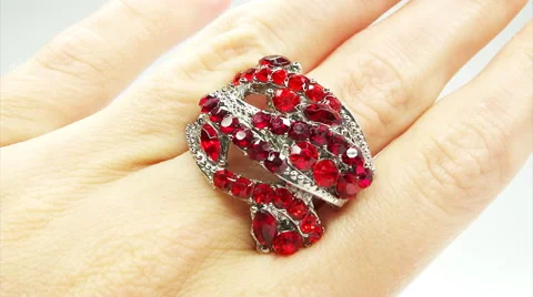 Jewelery ring with red ruby crystals putting on the finger Stock Footage 45346668