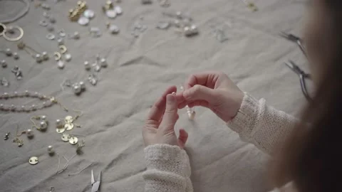 Jewelry designer working in studio making pearl bracelet Stock Footage 132058135