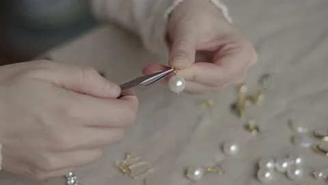 Jewelry designer working with tools making pearl earrings Stock Footage 132054945