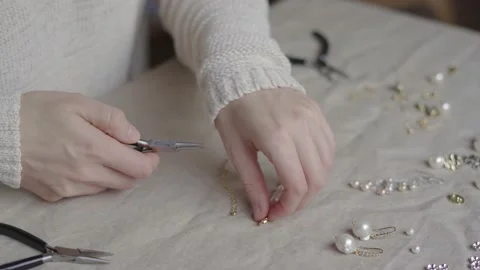 Jewelry designer working with tools making rose quartz gemstone necklace Stock Footage 132055653