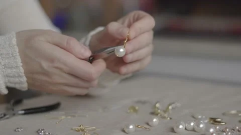 Jewelry designer working with tools making pearl earrings Stock Footage