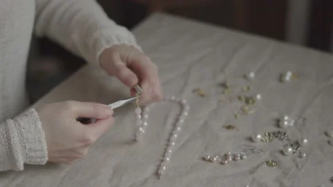 Jewelry designer working with tools making rose quartz gemstone necklace Stock Footage 132059373