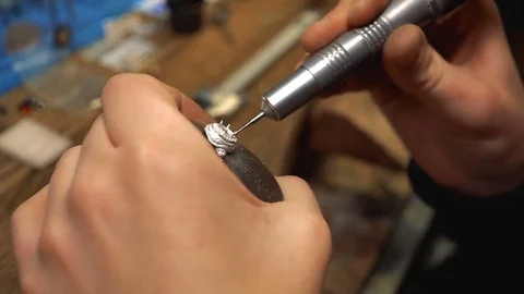 Jewelry master turns the silver ring in the vice and drills a hole for the inlay Stock-Footage 73527648
