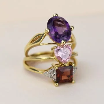 Jewelry ring with amethyst and ruby on a white background 스톡 사진