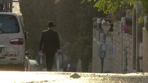 Jewish man walks down Jerusalem street at Sunset Stock Footage 86759855