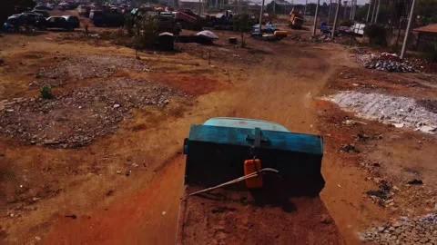 Jib down of a long dirt road in rural Nigeria, a car drives over the trail Stock Footage 331960295