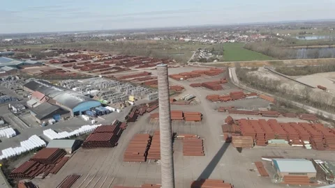 Jib up of old smoke stack overlooking large industrial junk yard 動画素材 150817752