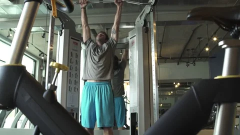 Jib shot of a man doing pull-ups in a gym Stock Footage 76235022