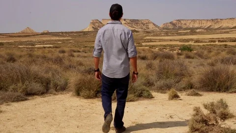 Jib shot of man entering the desert Stock Footage 80676019