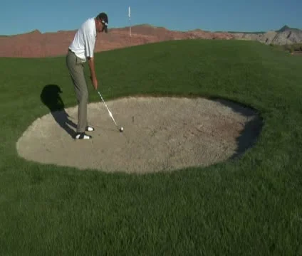 Jib  shot of man hitting a golf ball from sand trap Stock Footage 21649129