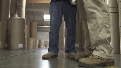 Jib shot of two warehouse workers talking Stock Footage 76225378