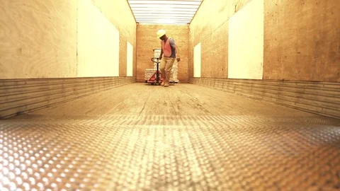 Jib shot of a worker pulling a pallet truck 動画素材 76534920