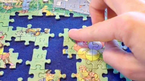 Jigsaw piece being placed Stockbeeldmateriaal 93505659
