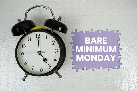 Jigsaw puzzle with a missing piece with "Bare Minimum Monday" and alarm clo.. Stock Photos
