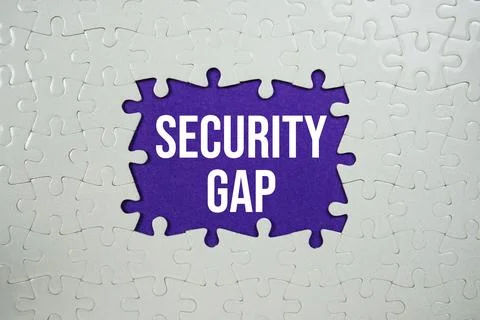 Jigsaw puzzle with a missing piece with "Security Gap" on purple background Stock Photos